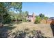 Large backyard featuring a well-kept lawn surrounded by mature trees and a wood fence at 8952 W Stanford Ave, Denver, CO 80123