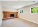 Finished basement with brick fireplace, neutral carpet and natural light from multiple windows at 8952 W Stanford Ave, Denver, CO 80123