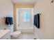 Bathroom featuring commode and window inside of shower/tub at 8952 W Stanford Ave, Denver, CO 80123