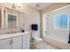 Bathroom with modern vanity, commode, and bright window in the shower/tub at 8952 W Stanford Ave, Denver, CO 80123