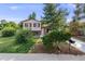 Charming home with a well-manicured lawn, mature trees, and a welcoming facade on a sunny day at 8952 W Stanford Ave, Denver, CO 80123