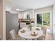 Bright kitchen with white cabinets, stainless steel appliances and dining table near sliding glass door at 8952 W Stanford Ave, Denver, CO 80123