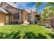 Expansive backyard with a patio, comfortable seating, and lush green lawn at 507 Ulster Way, Denver, CO 80230