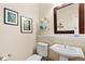 Charming half bath with a pedestal sink, decorative shelving, and neutral decor at 507 Ulster Way, Denver, CO 80230