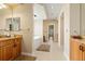 Spacious bathroom featuring dual vanities, a soaking tub, tiled floors, and views to bedroom at 507 Ulster Way, Denver, CO 80230