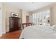 Comfortable bedroom with hardwood floors, a large window with plantation shutters, and a wooden dresser at 507 Ulster Way, Denver, CO 80230