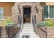 Inviting stone entryway with wrought iron railings leads to the front door of the home at 507 Ulster Way, Denver, CO 80230