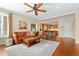 Cozy living room featuring a ceiling fan, a leather sofa, and hardwood floors at 507 Ulster Way, Denver, CO 80230