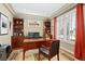 Elegant office with built-in shelving, a large window with plantation shutters, and hardwood floors at 507 Ulster Way, Denver, CO 80230