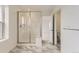 Modern bathroom featuring a glass-enclosed shower, marble floors, and neutral color palette at 8866 Waterleaf Ln, Littleton, CO 80125