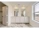 Bathroom with double sink vanity, quartz countertop, marble floors, and large window at 8866 Waterleaf Ln, Littleton, CO 80125