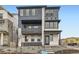 Modern three-story home featuring a second-story balcony and a textured facade at 8866 Waterleaf Ln, Littleton, CO 80125