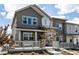 Stylish townhome showcasing a covered front porch with stone pillars and gray siding at 1500 Sun Way, Lafayette, CO 80026
