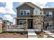 Charming townhome featuring stone accents, gray siding, and a cozy front porch at 1500 Sun Way, Lafayette, CO 80026