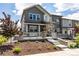 Exterior of home featuring a stone facade, covered porch, and landscaped front yard at 1500 Sun Way, Lafayette, CO 80026