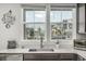 Close-up of the kitchen sink and counter area with a view to the outside neighborhood at 1500 Sun Way, Lafayette, CO 80026