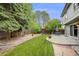 Landscaped backyard featuring a patio, privacy fence, retaining wall and mature trees at 3889 S Fraser St, Aurora, CO 80014