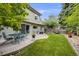 Green backyard featuring a patio with an outdoor dining set, lawn area, and privacy fence at 3889 S Fraser St, Aurora, CO 80014