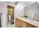 Well-lit bathroom featuring a double sink vanity, ample counter space, and a separate shower at 3889 S Fraser St, Aurora, CO 80014
