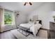 Light-filled bedroom featuring a large window, vaulted ceiling, and a comfortable bed with stylish accents at 3889 S Fraser St, Aurora, CO 80014