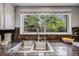 Close up view of the kitchen sink and countertops with large window providing natural light at 3889 S Fraser St, Aurora, CO 80014