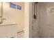 Bright bathroom with white marble tile and a sink with a white cabinet at 4401 S Yosemite Ct, Greenwood Village, CO 80111