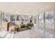 A bright sunroom featuring wicker furniture, tile flooring, and plenty of natural light through large windows at 4401 S Yosemite Ct, Greenwood Village, CO 80111