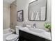 Cozy bathroom with modern fixtures featuring a shower over tub, black vanity, and framed mirror at 13586 W Warren Cir, Lakewood, CO 80228