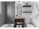 Cozy bathroom with a gray tiled shower and an elegant vanity with open storage below at 13586 W Warren Cir, Lakewood, CO 80228