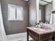 Updated bathroom with a pink granite countertop and a shower-tub combination with gray tiling at 13586 W Warren Cir, Lakewood, CO 80228