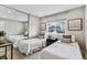 Charming bedroom featuring twin beds, neutral decor, and a sliding closet mirror that enhances space at 13586 W Warren Cir, Lakewood, CO 80228