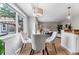 Bright dining area features a glass table, plush chairs, and wood floors adjacent to the living area at 13586 W Warren Cir, Lakewood, CO 80228