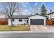 Charming home featuring a gray garage door, well-kept lawn, and lovely tree at 13586 W Warren Cir, Lakewood, CO 80228