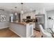 Bright kitchen featuring breakfast bar, stainless steel appliances, and hardwood floors at 13586 W Warren Cir, Lakewood, CO 80228