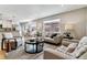 Inviting living room area featuring a view into the adjacent dining area, and neutral toned furniture at 13586 W Warren Cir, Lakewood, CO 80228