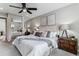 Comfortable main bedroom with a decorative ceiling fan, large bed, and mirrored closet at 13586 W Warren Cir, Lakewood, CO 80228