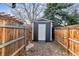 Backyard shed is enclosed by a wood fence, offering additional storage at 13586 W Warren Cir, Lakewood, CO 80228