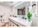 Modern bathroom with dual sinks, white countertops, and backlit mirror at 1250 N Humboldt St # 202, Denver, CO 80218