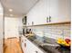 Galley kitchen with black granite countertops, white cabinets, stainless steel appliances, and hardwood floors at 1250 N Humboldt St # 202, Denver, CO 80218