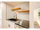 Modern kitchen boasts granite counters, stainless steel dishwasher, black sink and open wood shelving at 1250 N Humboldt St # 202, Denver, CO 80218