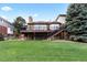 Lush green backyard with a large deck and stairs, ideal for outdoor living and entertaining at 9232 Rockport Ln, Highlands Ranch, CO 80126
