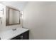Modern powder room featuring a sleek vanity with a black cabinet and modern mirror at 9232 Rockport Ln, Highlands Ranch, CO 80126