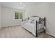 Bedroom with white walls, black-frame bed, and a window overlooking greenery at 9232 Rockport Ln, Highlands Ranch, CO 80126