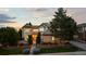 Charming two-story home with warm interior lights and lush landscaping at dusk at 9232 Rockport Ln, Highlands Ranch, CO 80126