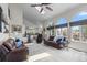 Bright living room features two leather couches, high ceilings, and large windows at 9232 Rockport Ln, Highlands Ranch, CO 80126