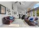 Bright living room features two leather couches, high ceilings, and fireplace at 9232 Rockport Ln, Highlands Ranch, CO 80126