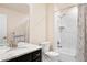 Bright bathroom features a shower over tub, modern fixtures, granite vanity, and a decorative shower curtain at 10100 Isle St, Parker, CO 80134