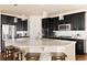 Modern kitchen with a large island, stainless steel appliances, and stylish dark cabinets at 10100 Isle St, Parker, CO 80134