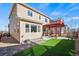 Backyard featuring artificial turf, stone landscaping, and a red pergola-covered patio with grill and seating at 15246 W 94Th Ave, Arvada, CO 80007