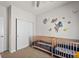 Bright Bedroom with closet, dual cribs, playful wall decor, and natural light at 15246 W 94Th Ave, Arvada, CO 80007